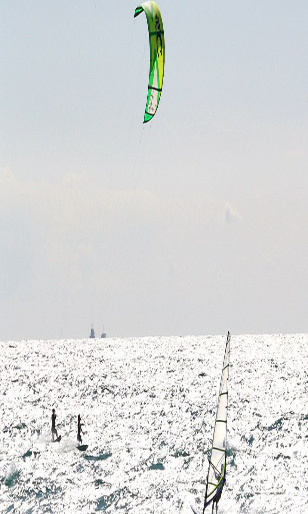 Surfer und Kiter am Strand
