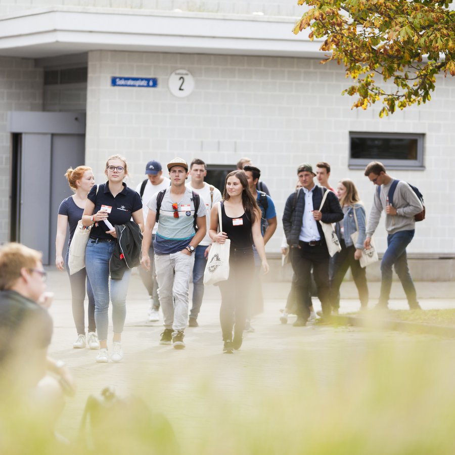 Campusimpression eine Gruppe junger Menschen schlendert über den Campus der FH Kiel.