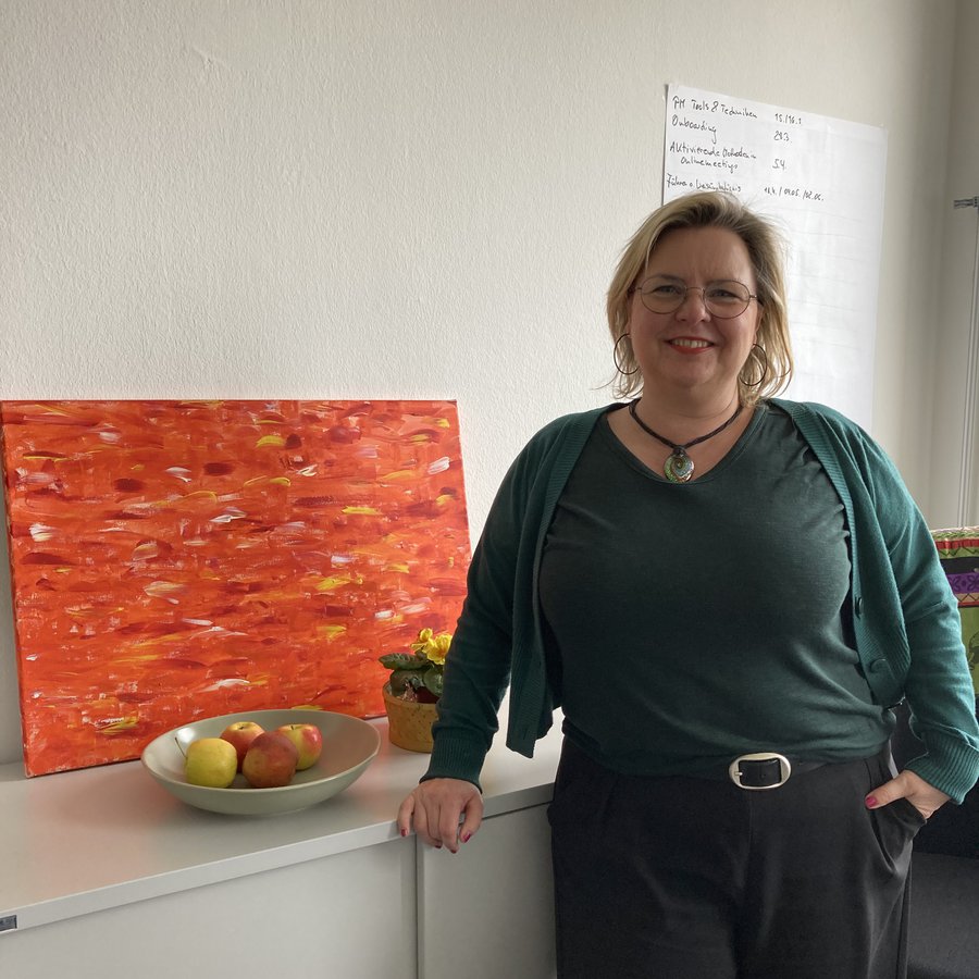 Eine Frau schaut lächelnd in die Kamera