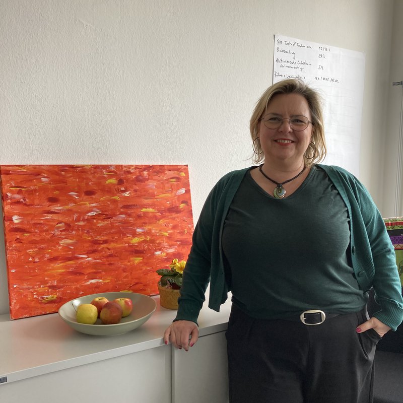 Eine Frau schaut lächelnd in die Kamera
