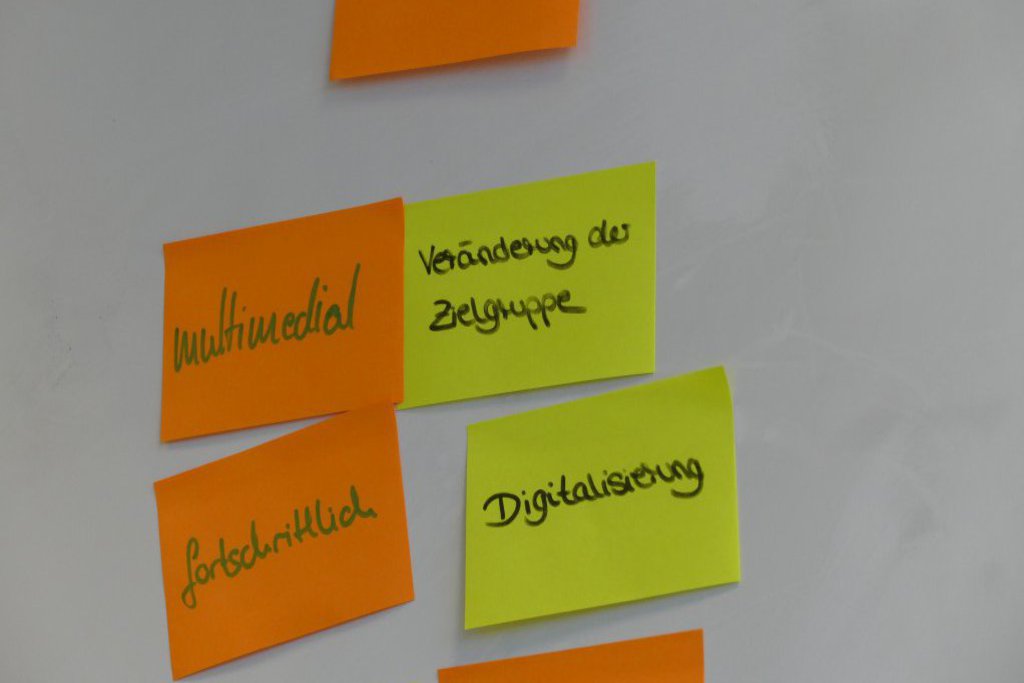An einem Whiteboard hängen beschreibende Post-its