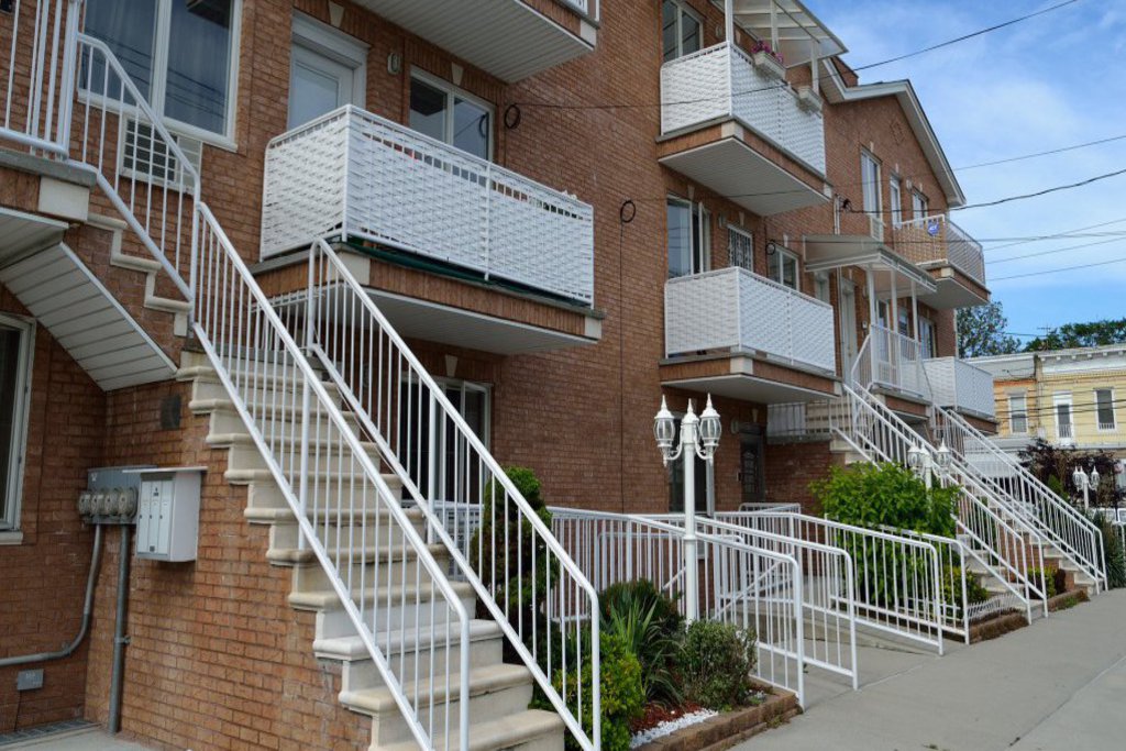 Verbundene Wohneinheiten mit ihren Treppenaufgängen und weissen Balkonbrüstungen.