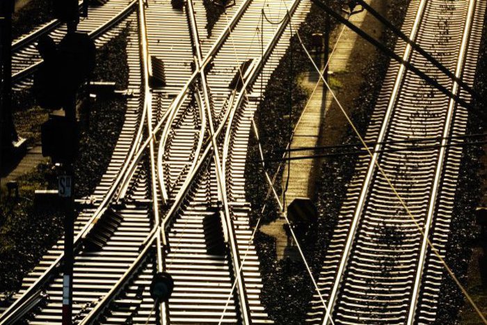Drei aus der Vogelperspektive fotografierte Bahngleise, von denen zwei sich kreuzen.