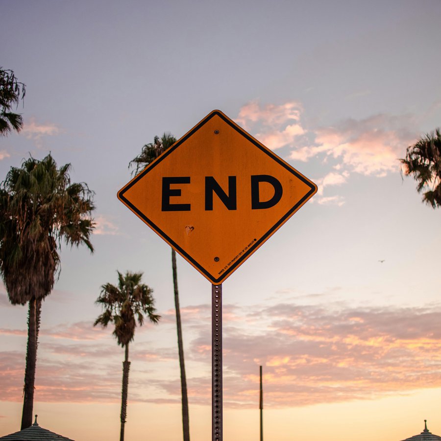 Ein Schild mit "End" und Palmen im Hintergrund