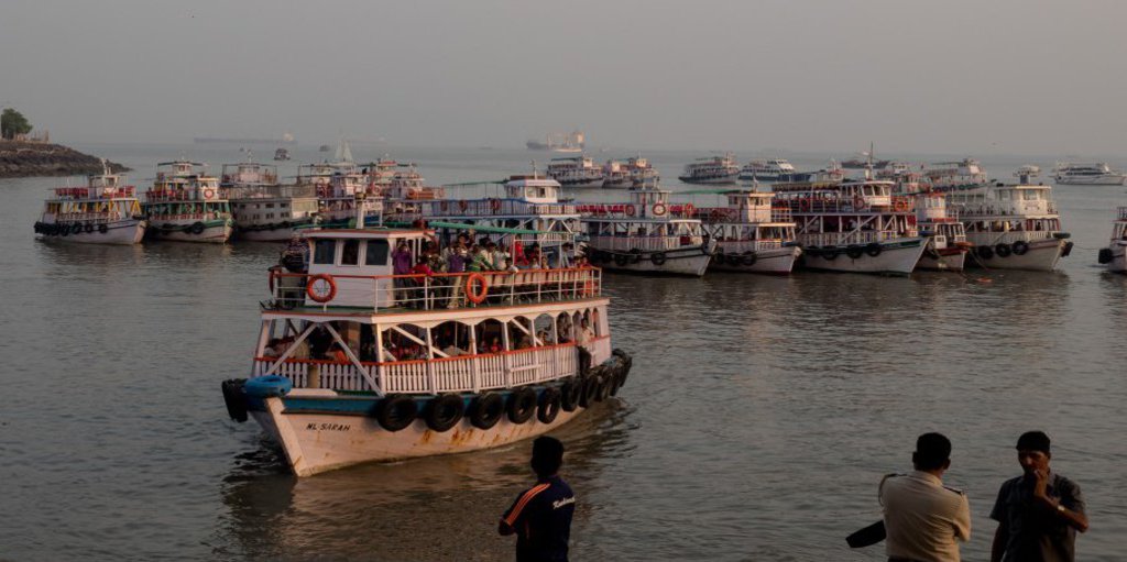 Mehrere Touristenschiffe legen an einer Bucht an.