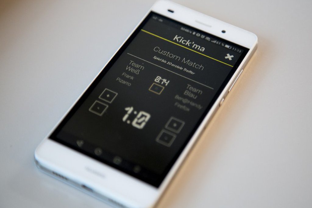 Ein weißes Smartphone auf dem eine App geöffnet ist, die das Verwalten von Tisch-Kicker-Spielen ermöglicht.