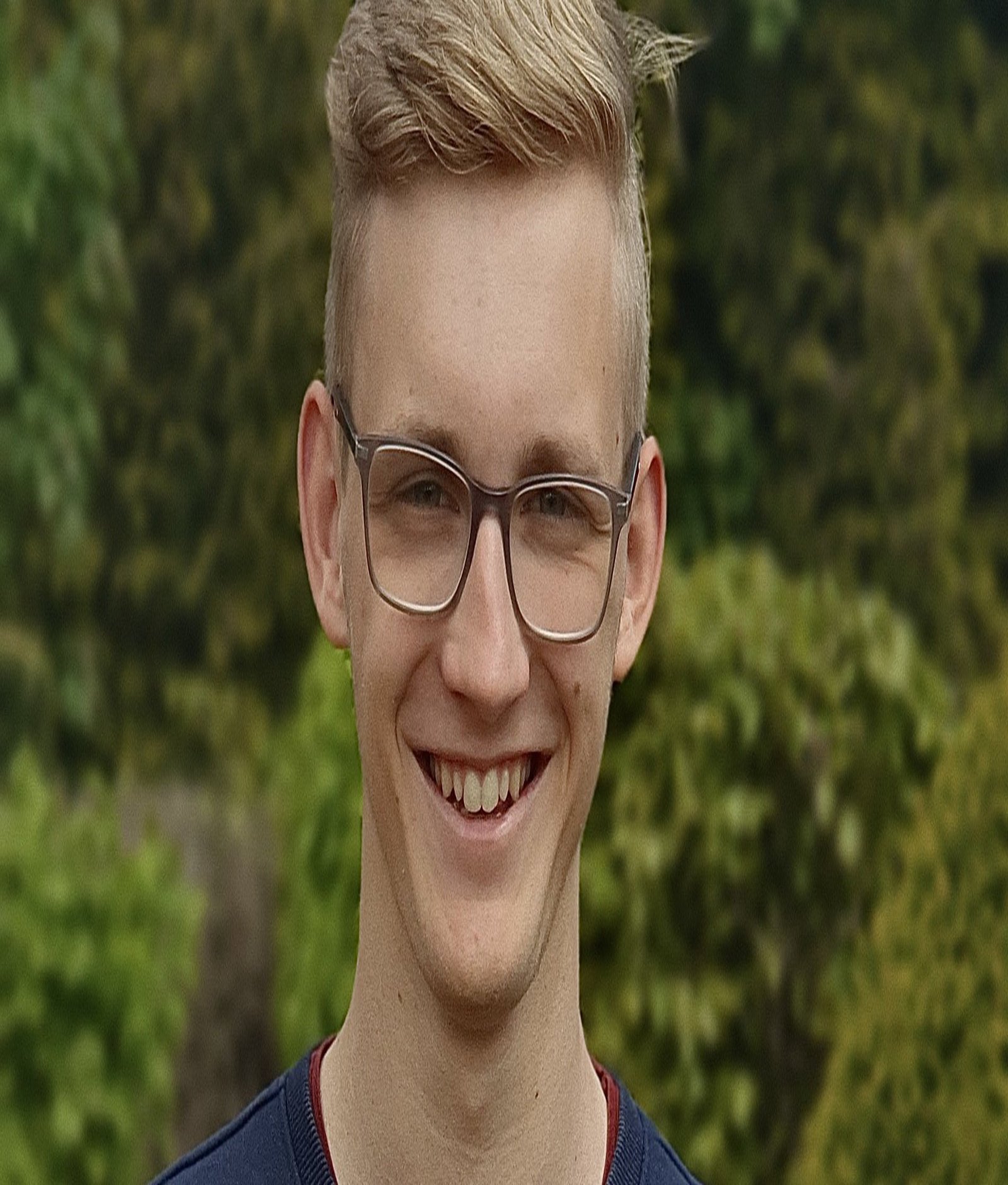 Portraitbild von dem Studenten Eric Koch vor einer Hecke.