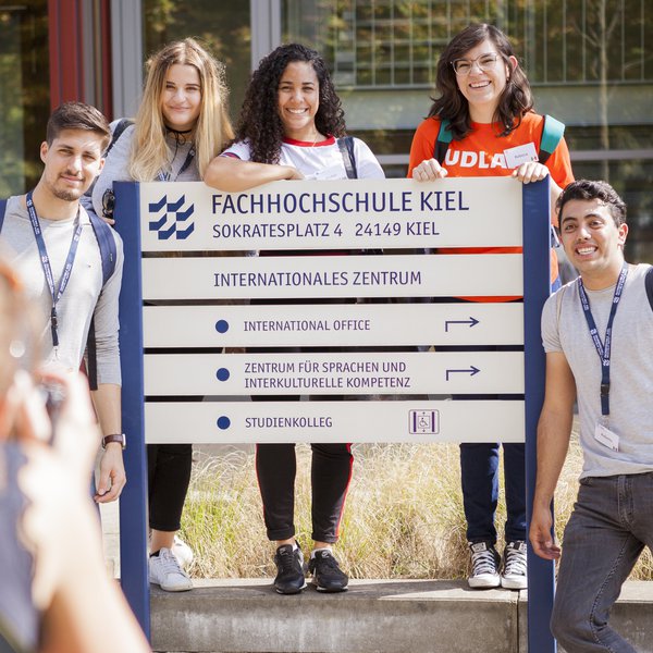 Studierende am Wegweiser vorm International Office