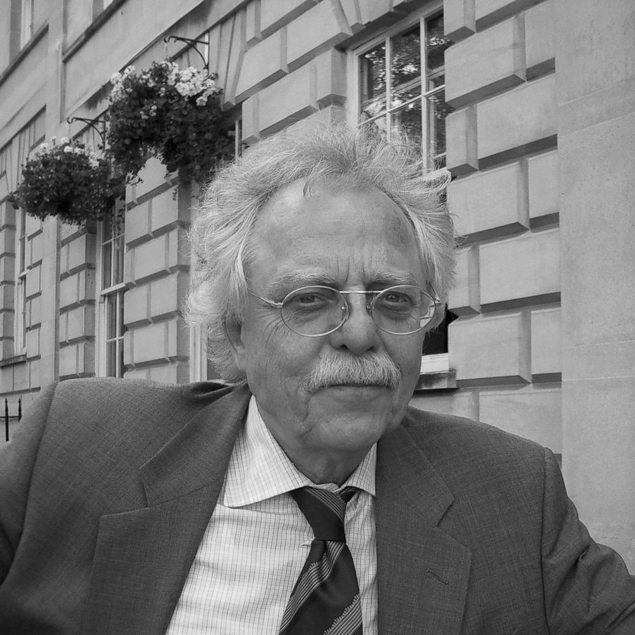 Das Foto zeigt ein Portrait von Professor Rolf Schulmeister vor einem Gebäude.