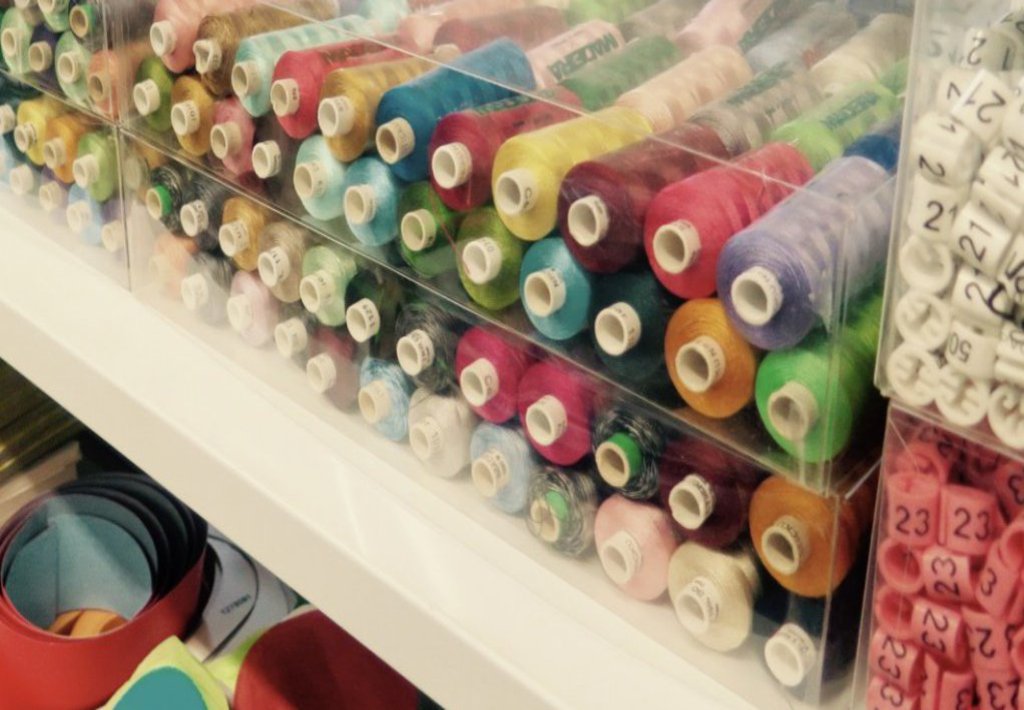 Ein großer Kasten mit vielen Rollen Nähgarn.