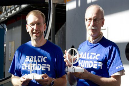 Zwei ältere Männer, in blauem "Baltic Thunder" T-Shirt, lächeln zufrieden in die Kamera.
