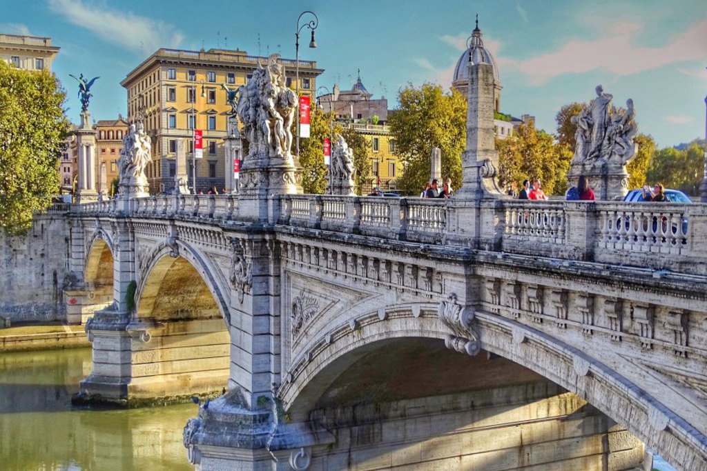 Eine alte schön verzierte Brücke mit Statuen darauf.