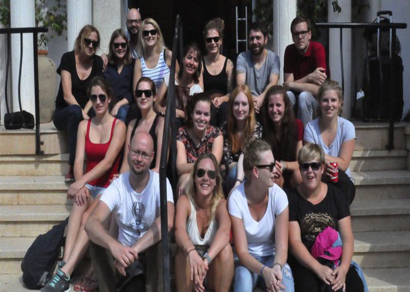 Eine Gruppe von Menschen posiert auf einer Steintreppe.