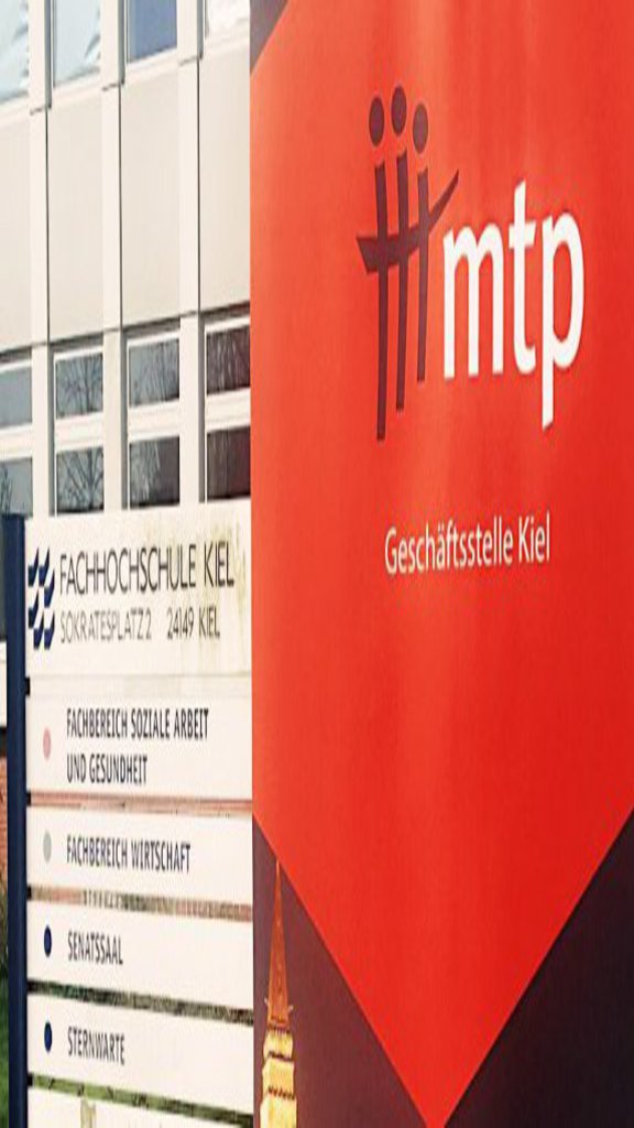 Ein PLakat in Rot und dunkel Blau gehalten steht vor dem Eingang eines Gebäudes.