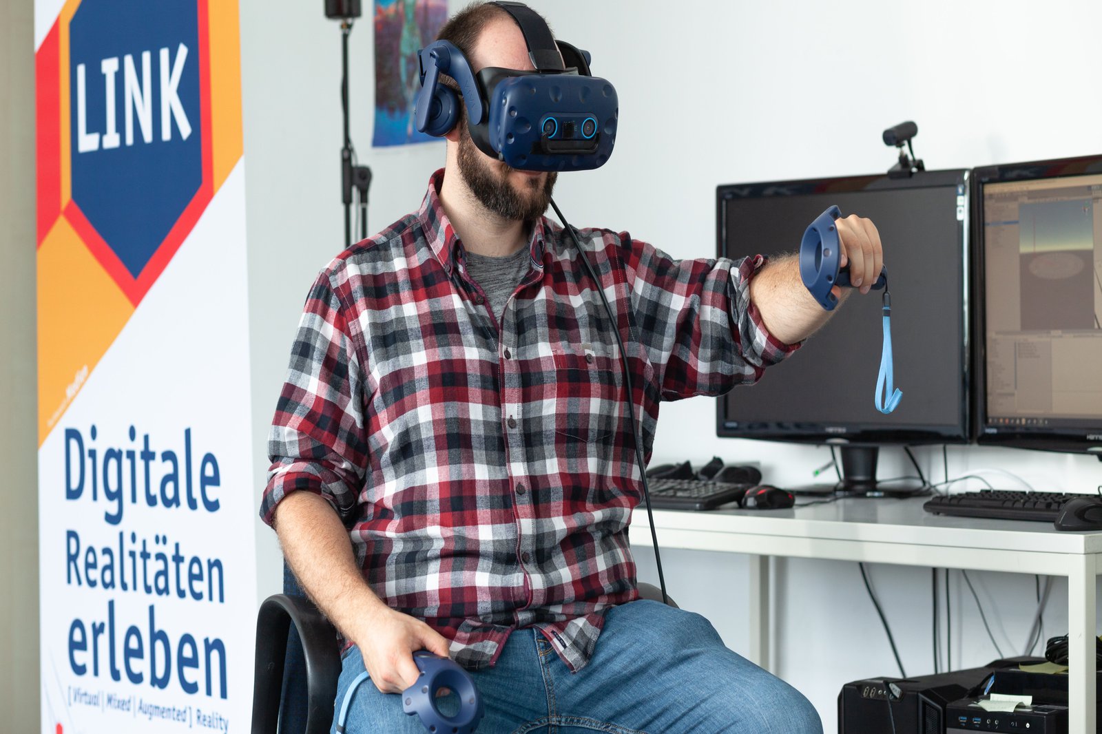 Ein Mann sitzt auf einem Stuhl und trägt eine VR-Brille