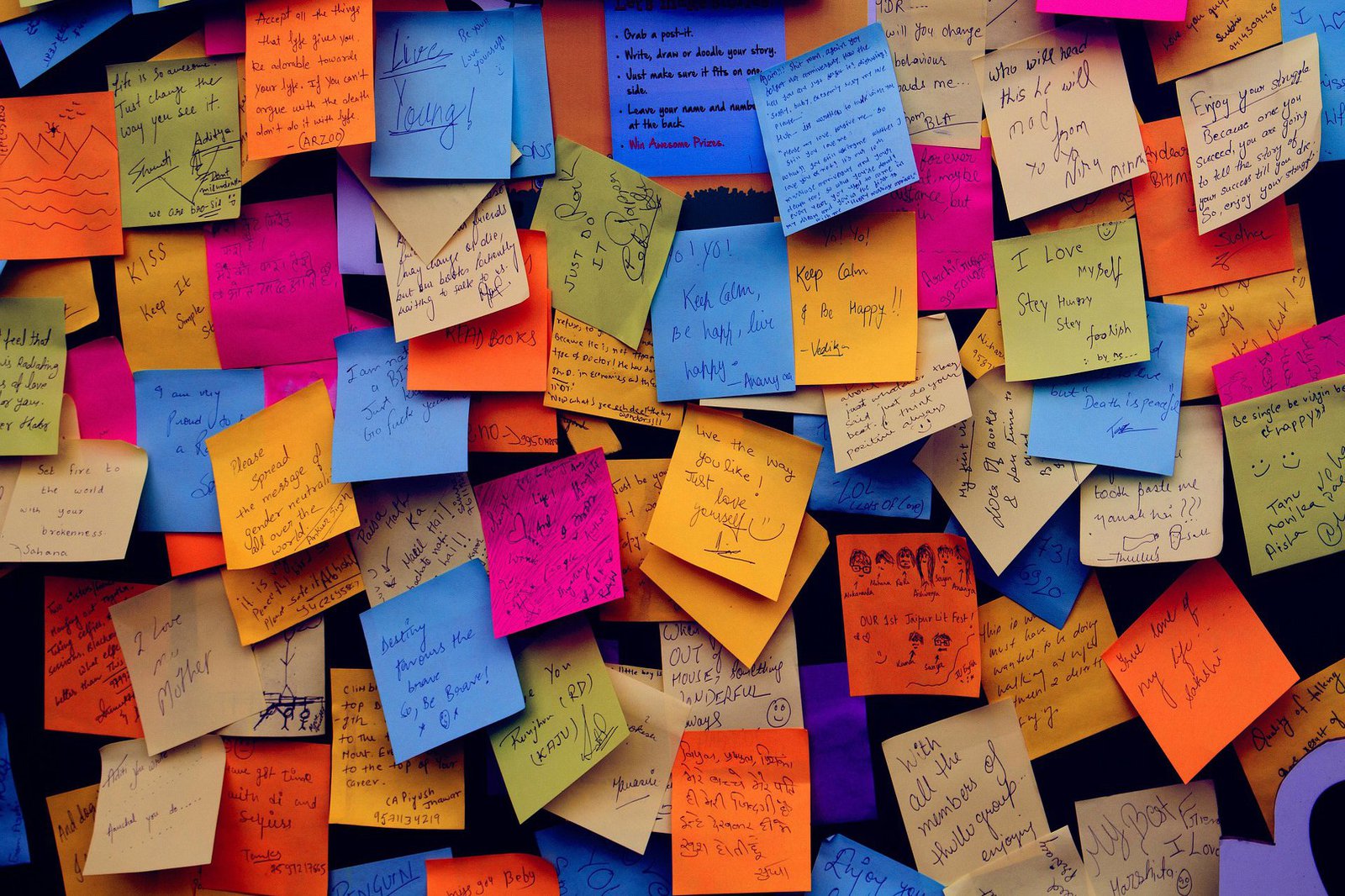 Eine Wand zugeklebt mit bunten, beschriebenen Post-its.