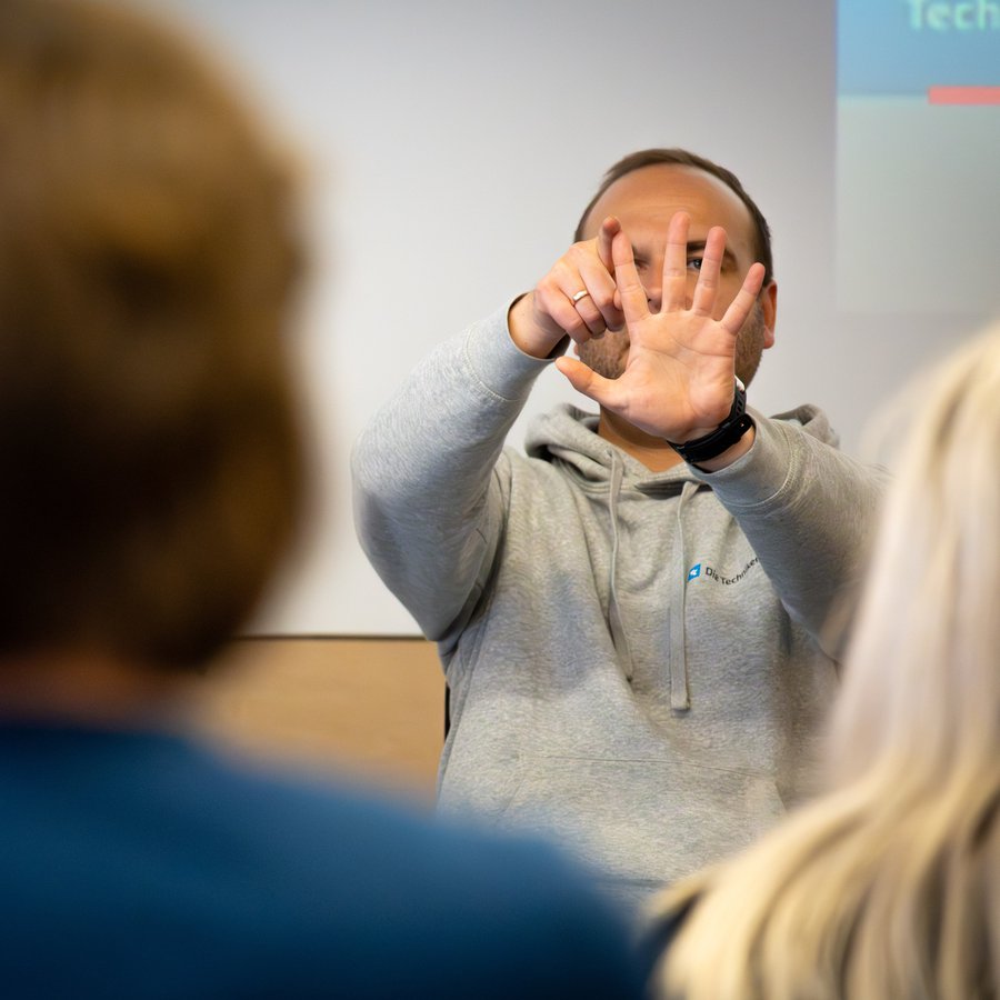 Mann streckt Hand mit gespreizten Fingern vors Gesicht 