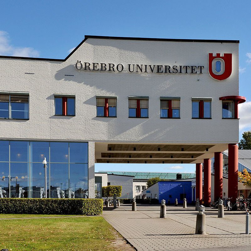 Ein weißes Hochschulgebäude vor blauem Himmel. 