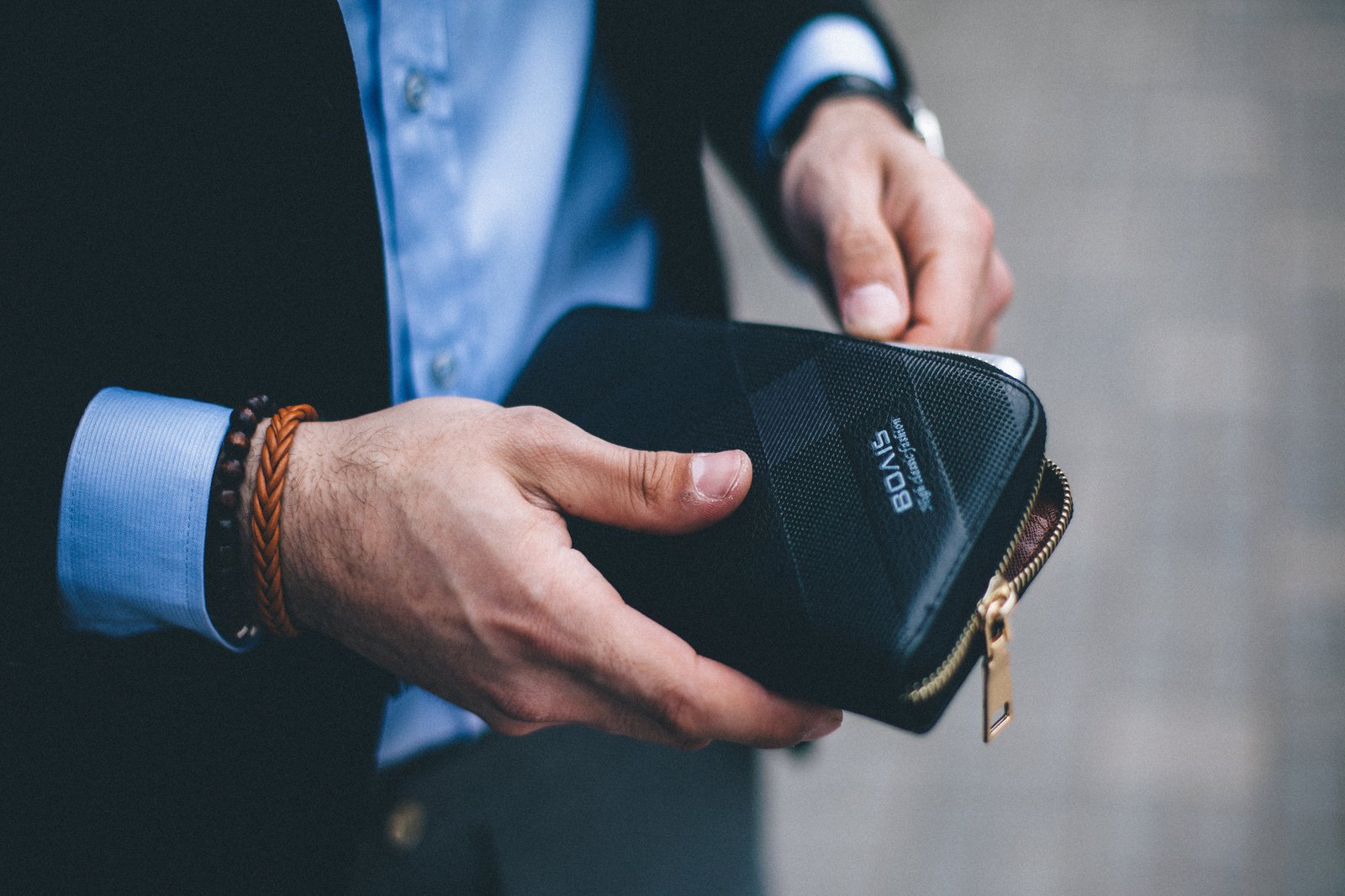 Ein Mann im Anzug verstaut sein Handy, in einer dafür vorgesehenen Tasche.