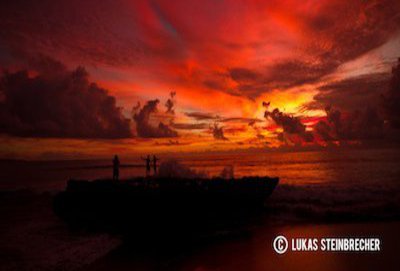 Über dem Meer bilden Wolken und Sonnenuntergang ein farbenfrohes Spektakel.