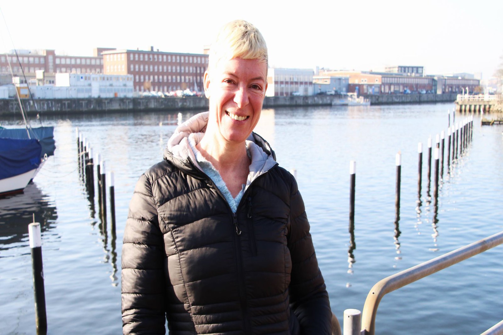 Eine Frau posiert mit breitem Lächeln vor der Schwentinemündung.