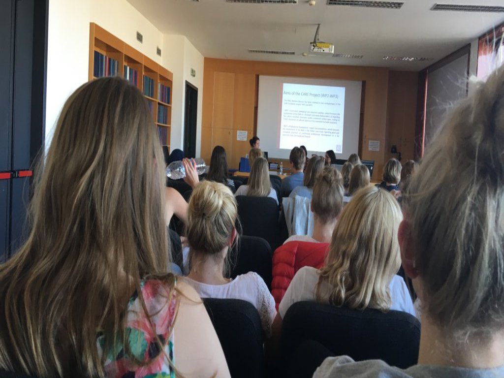 Studierende sitzen in einem Seminarraum und nehmen an einem Vortrag teil.