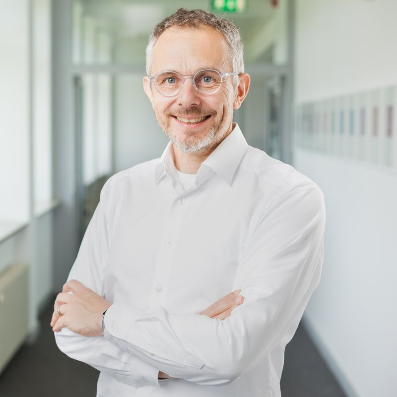 Portrait eines Mannes mit Brille auf einem Flur