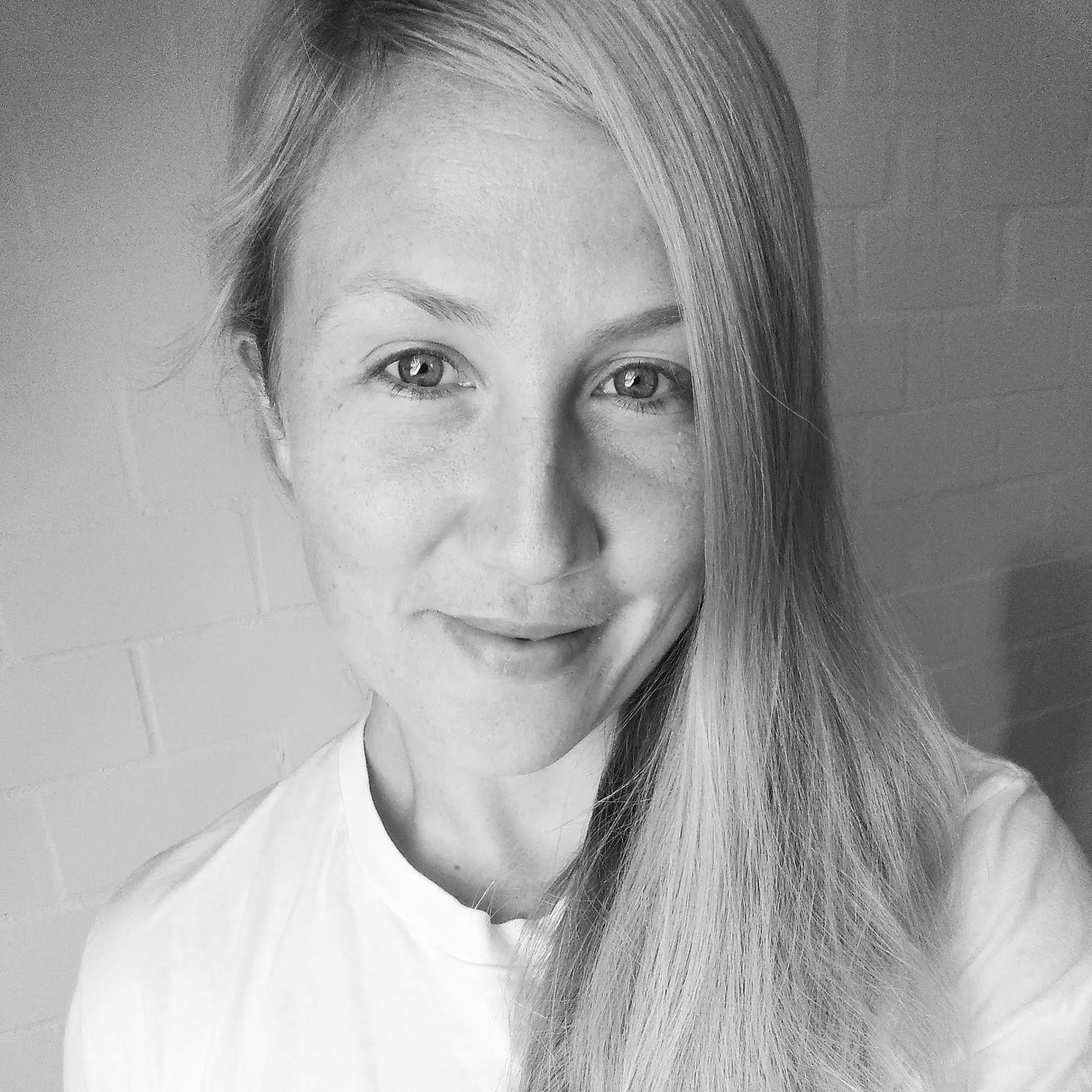 Das Schwarz-Weiss-Bild zeigt eine Frau, die in die Kamera grinst.