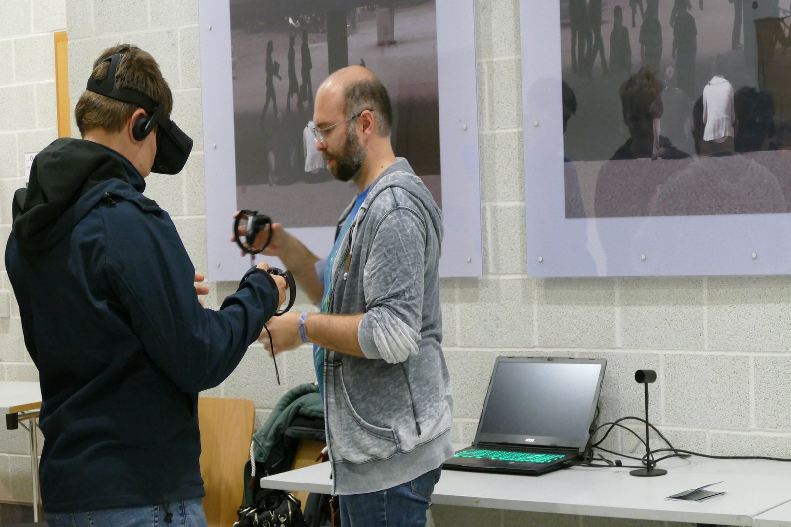 Ein Mann stattet einen weiter mit VR-Brille und Zubehör aus.