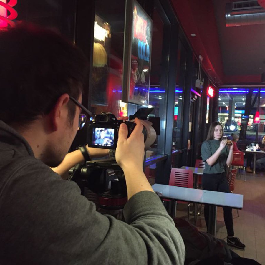 Ein Mann fotografiert eine Frau, die in einem Kino posiert.