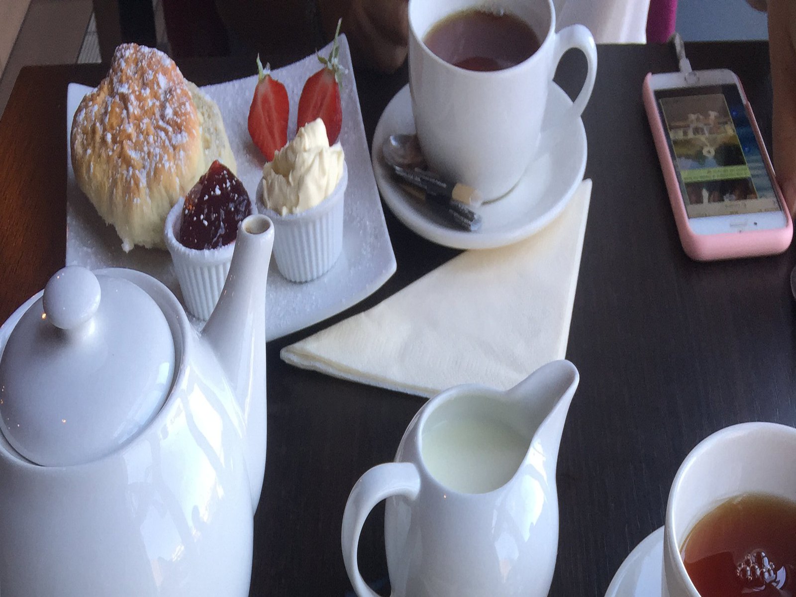 Ein Frühstücksgedeck mit Tee, Brot und Marmelade.