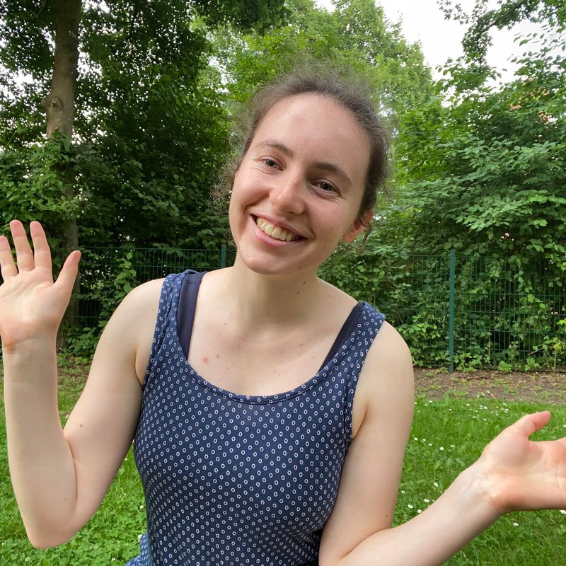 Eine Frau winkt in die Kamera