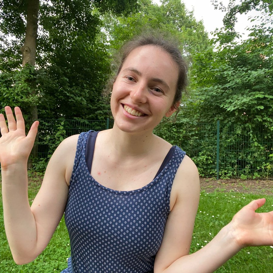 Eine Frau winkt in die Kamera