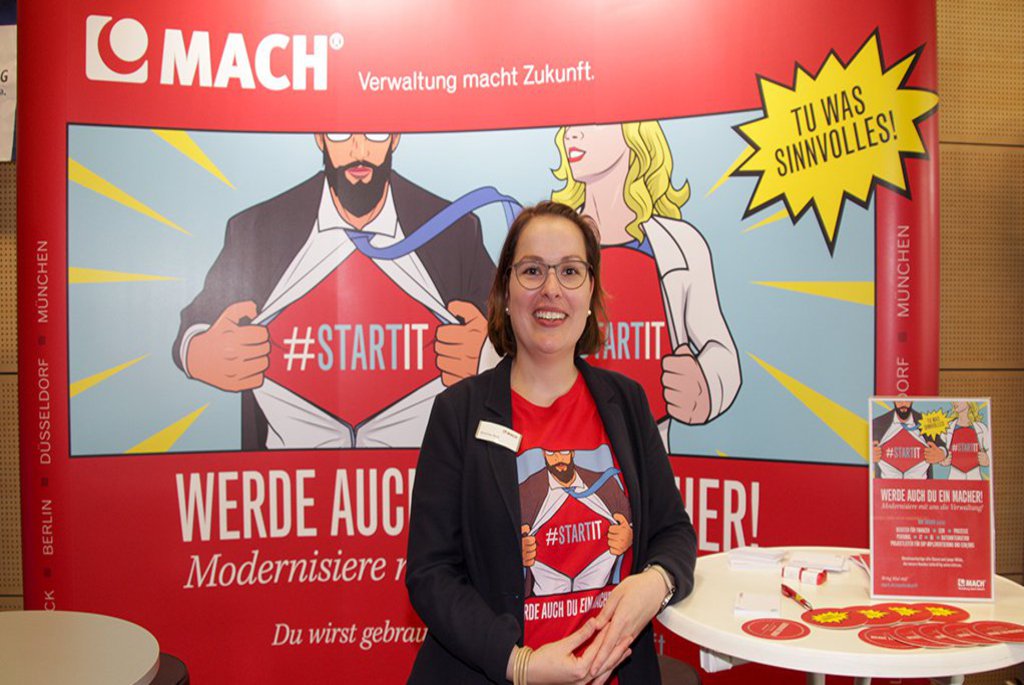 eine Frau vor einer Messewand