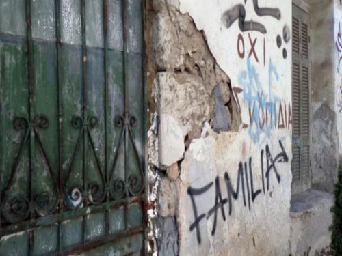 Die Hauswand eines heruntergekommen Gebäudes, auf die "FAMILIA" gesprüht wurde.