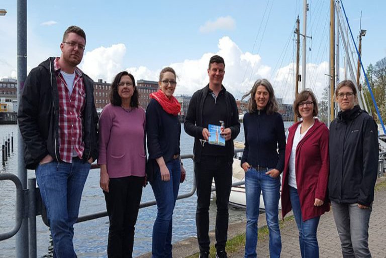 Eine Gruppe posiert am Yachthafen der Schwentinemündung.