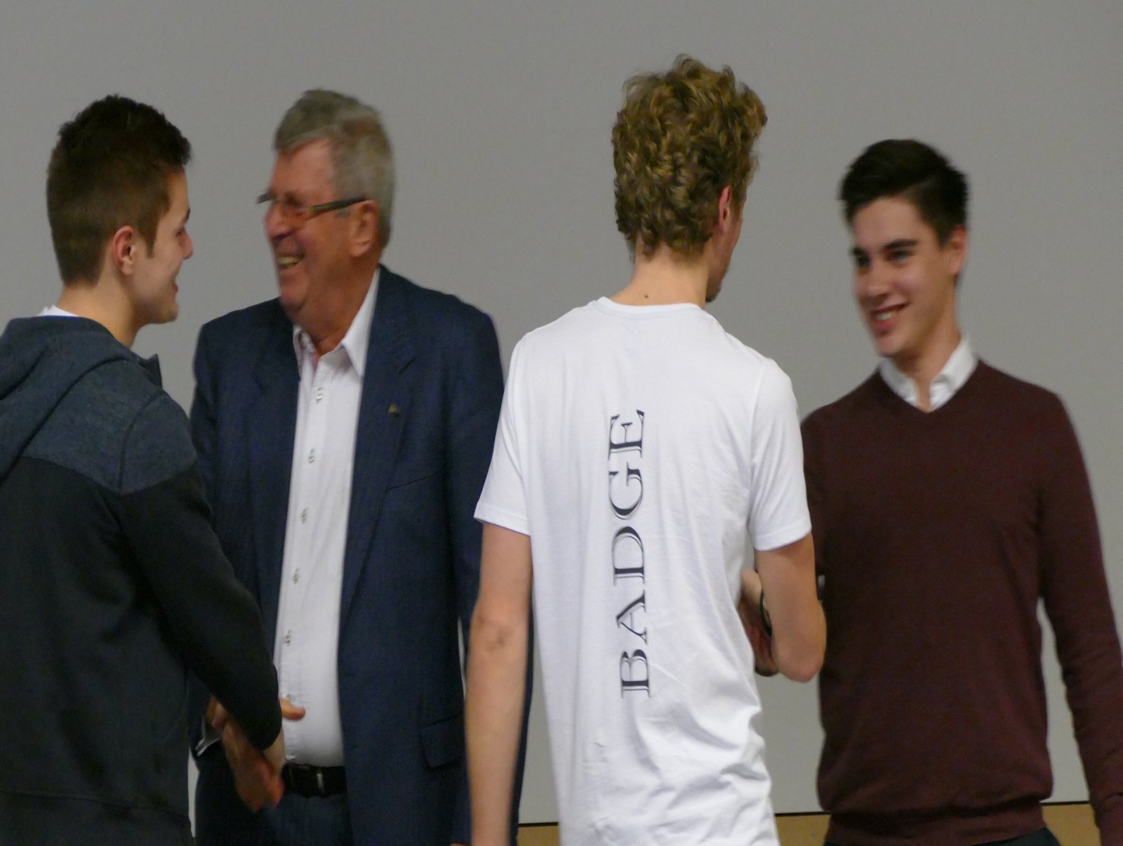 Das Team „Badge“ nimmt die Glückwünsche der Jury für den geteilten dritten Platz auf der Bühne entgegen. Foto: Königs