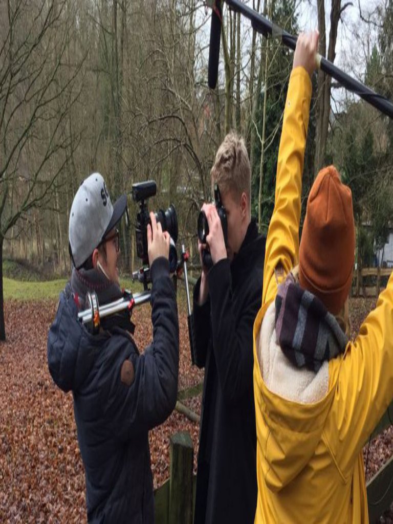 Zwei Männer fotografieren sich gegenseitig, ein dritter steht daneben und hält ein Mikrofon über sie.