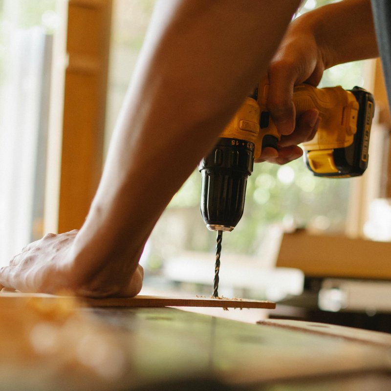 Jemand bohrt ein Loch in ein Brett