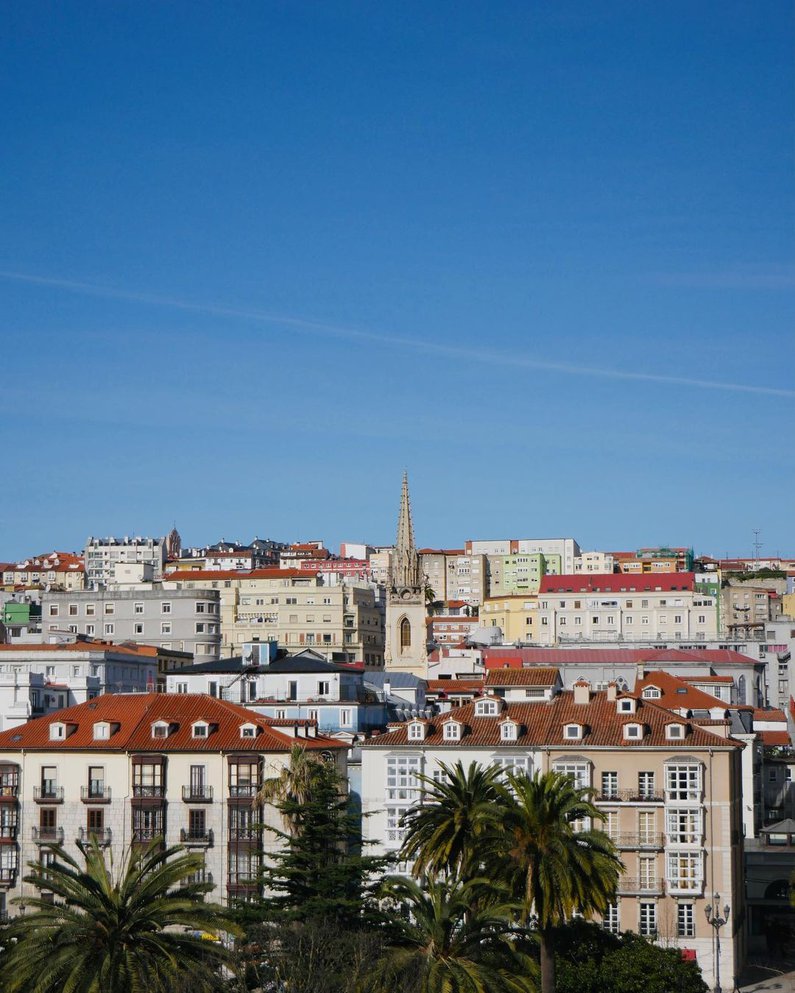 eine malerische Kulisse von weißen Häuserfassaden vor einem strahlend blauen Himmel an der Küste