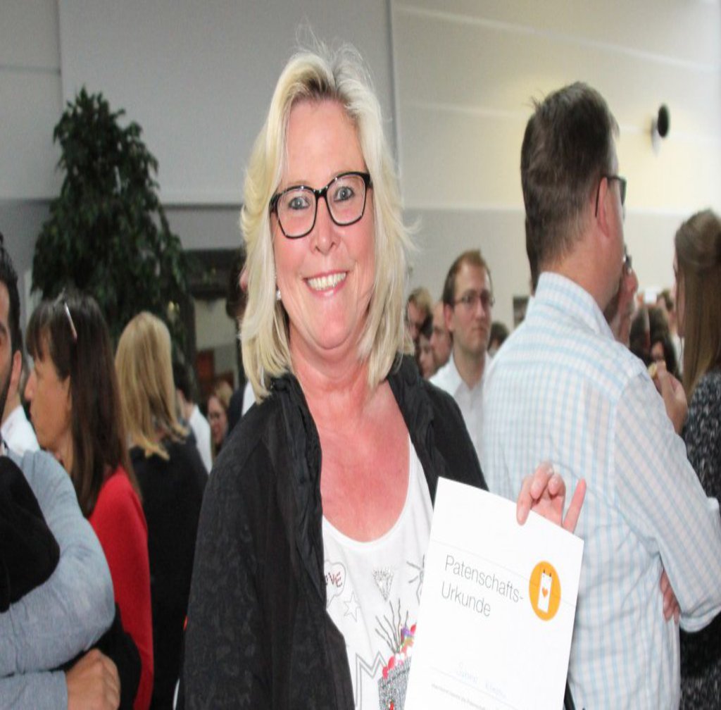 Blonde Frau mit einer Urkunde in der Hand