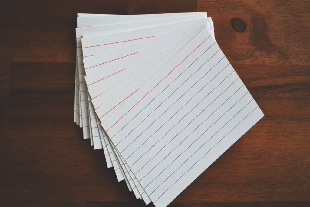 Ein Stapel Karteikarten befindet sich auf einem Holztisch.