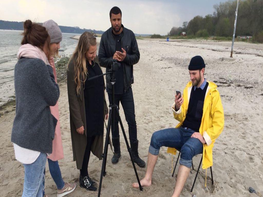 Das Bild zeigt vier Studierende am Strand.