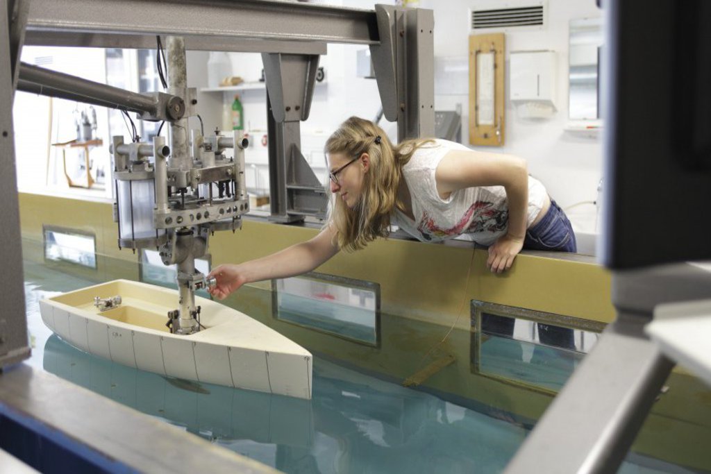 Eine Frau justiert etwas an einem Simulator für Boote.