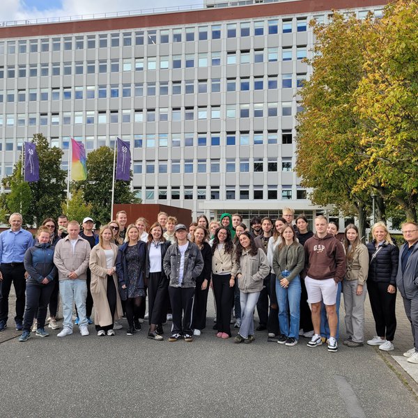 eine Gruppe Studierender vor Gebäude C3 der FH Kiel am Sokratesplatz