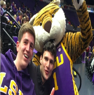 Joshua, gemeinsam mit einem Freund und dem Uni-Maskottchen bei einem Sportevent. 