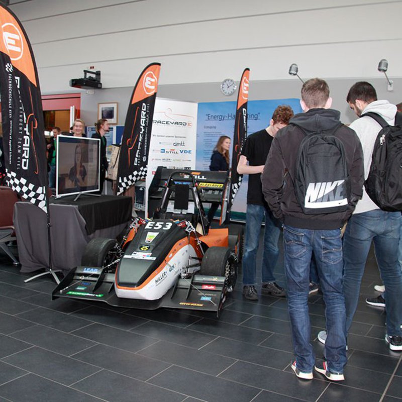 Rennauto und Menschen, die daneben stehen