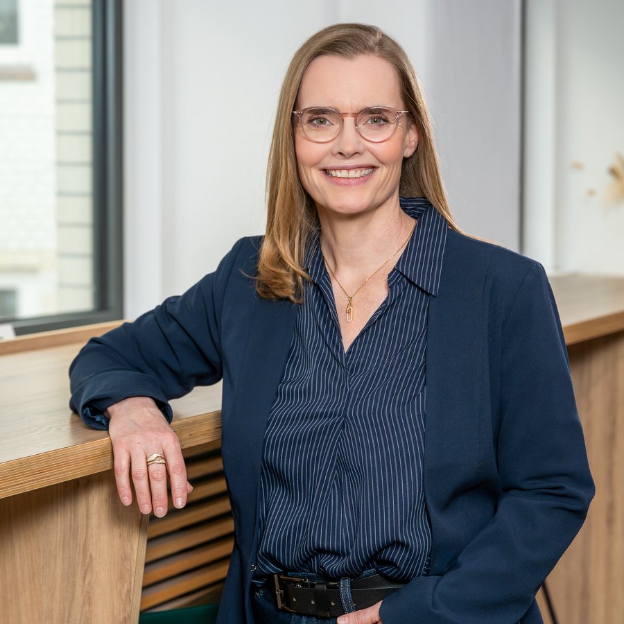 eine Frau lehnt sich an eine Fensterbank