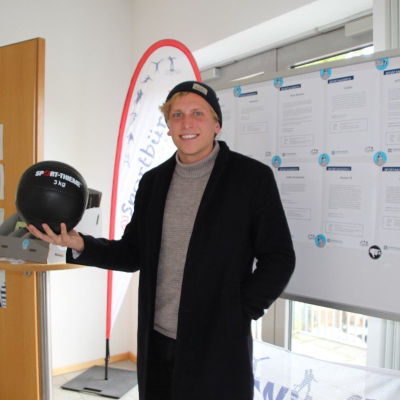 Mann mit 3-Kg-Ball in der Hand