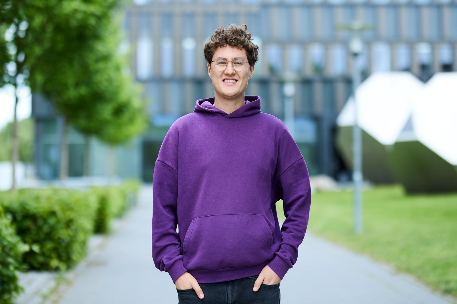 ein Studierender der HAW Kiel steht in lilafarbenem Hoodie vor dem Lerndock23 der HAW Kiel